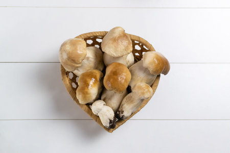 Porcini mushrooms in a wicker basket on a light background. Autumn gifts. Horizontal orientation....