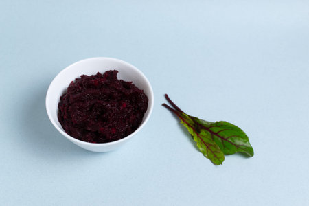 Natural beetroot wait with green beet leaves on a blue background. Vegetarianism concept. Copy...