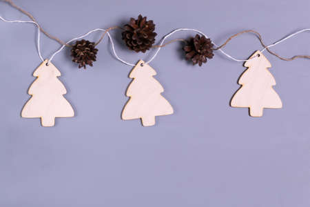 New Year's garland of Wooden trees and cones on a gray background. Natural Christmas decor concept. Copy space. Top view.の写真素材