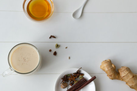 Masala tea in a glass cup with spices on a white background. Indian beverage. Horizontal orientation. Copy space. Top view.の写真素材