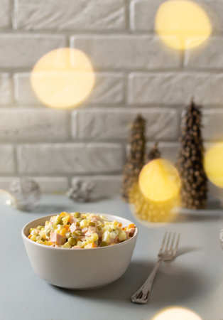 Traditional Olivier salad russian in a bowl on a gray background. Festive Russian cuisine. Copy space. Vertical orientation.の写真素材