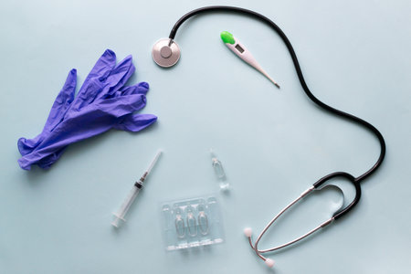 Vaccine and syringe with stethoscope and medical gloves on a blue background. Vaccination.の写真素材