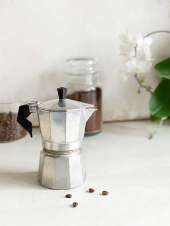 The concept of making coffee in a home kitchen. The geyser coffee maker is on the table next to the coffee cans. Vertical orientation. Copy space.の写真素材