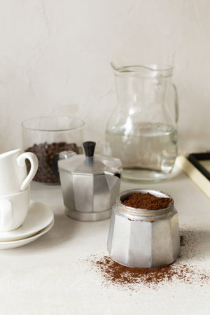 The process of making coffee at home. Coffee is poured into the geyser coffee maker in the home kitchen. Vertical orientation.の写真素材