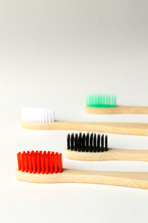 Four multi-colored bamboo toothbrushes. Eco friendly stuff concept. Copy space. Vertical orientation. Selective focus.の写真素材