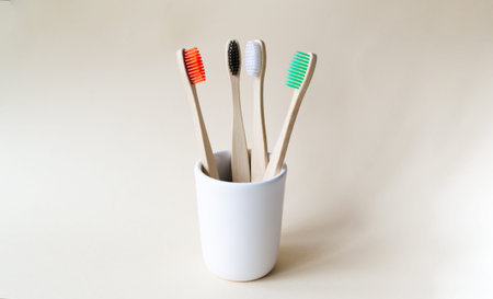 Four multi-colored bamboo toothbrushes in a ceramic glass. Eco friendly stuff concept. Copy space....