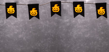 Garland for Halloween. Orange pumpkins with scary faces on a black background. Party decor. Banner. Copy space.の写真素材