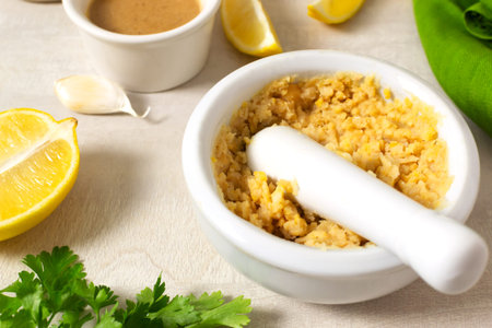 Mix the boiled chickpeas and garlic with lemon juice thoroughly in a ceramic mortar. Ingredients for...