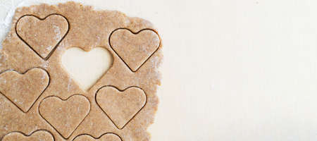 The process of making heart-shaped whole wheat flour cookies. The concept of festive home baking. Valentine's Day. top view. Banner. copyspace.の写真素材
