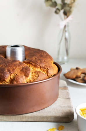 Easter cake with raisins in an aluminum shape on a wooden cutting board in the kitchen. Festive pastries for a family dinner. Homemade food concept. vertical orientation.の写真素材