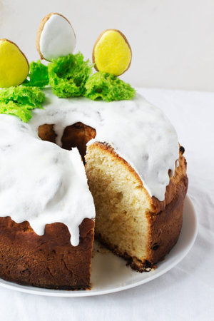 Easter cake with raisins decorated with white icing and gingerbread in the shape of Easter eggs on...