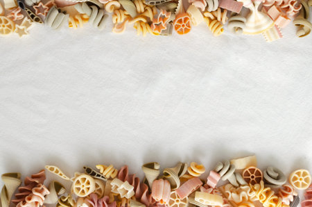 Background Mix of multi-colored Italian pasta on a light background. Concept alternative pasta....