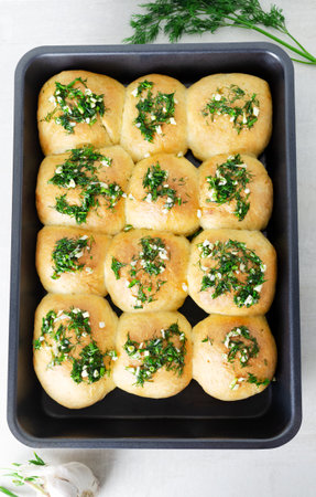 Buns with garlic and dill sauce with oil. Preparation of pampushky (Pampushky), traditional Ukrainian buns for borsch. The concept of traditional dishes. homemade baking. top viewの写真素材