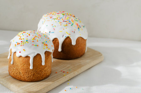 Two Traditional Ukrainian kulich on a cutting board on a white tablecloth. The concept of festive Easter baking. selective focus. horizontal orientation.の写真素材