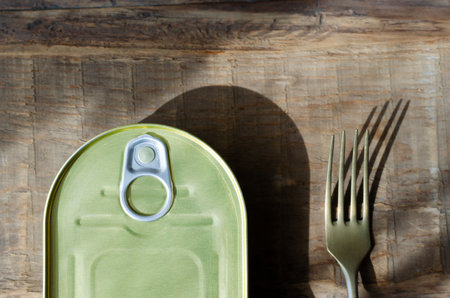 Can with a fork on a wooden table. Tinned fish concept. rustic style. horizontal orientation. top view.の写真素材