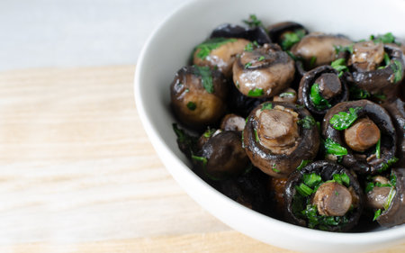 Fried champignons with garlic and parsley in a gray bowl. Vegetarian lifestyle concept. horizontal orientation. selective focus. copyspace.の写真素材