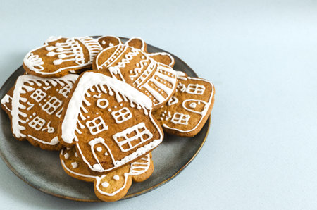 Gingerbread cookies with white icing on a gray plate on a gray background. Minimalism style. The concept of festive food. Copy space. Horizontal orientation. Copy spaceの写真素材