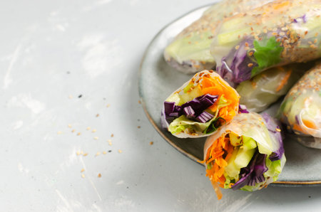 Vegetarian vietnamese spring rolls with carrot, cucumber, red cabbage, cilantro, sesame and rice...
