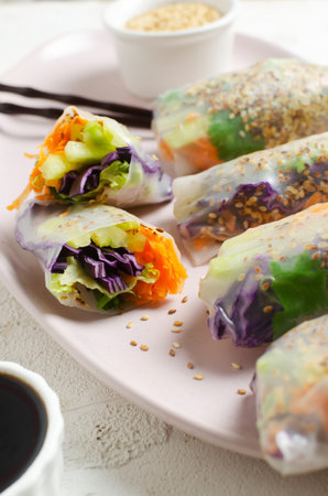 Vegetarian vietnamese spring rolls with carrot, cucumber, red cabbage, cilantro, sesame and rice...