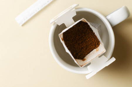 Drip coffee bag in a cup on a yellow background. A quick way to prepare a tasty and aromatic drink. Horizontal orientation. Top view. Copy spaceの写真素材