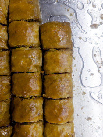 Honey baklava with pistachio crumbs on a metal tray. Traditional Turkish food concept. Sweet pastry....