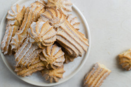 Tasty shortbread cookies with beautiful edges and powdered sugar on a gray background. Coffee time...