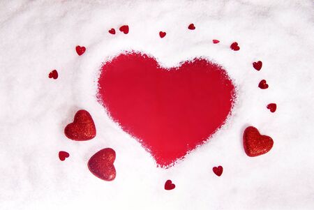 Snow framing shape of a heart surrounded by glitter heartsの写真素材