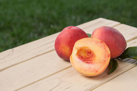 Freshly picked organic peaches with leavesの写真素材