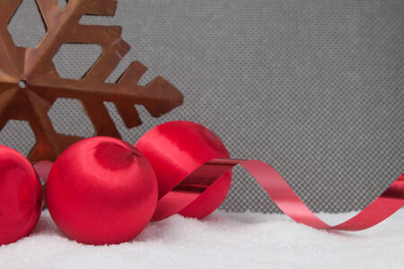 Three vintage christmas ornaments with ribbon and a star on a grey backgroundの写真素材