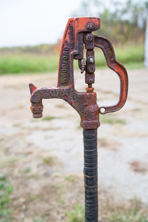 Old rusted hand pump water spigot used on a farmの写真素材