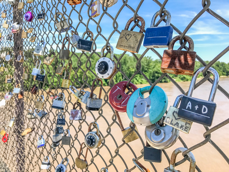 Padlocks line a chainlink fence along a Missouri riverfront bike trailの写真素材