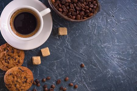 breakfast  A cup of coffee with pieces of cane sugar, biscuits with chocolate and a vase with coffee beans. Top viewの写真素材