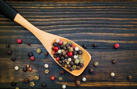 Spice. Mix of peppers in a wooden spoon, on a wooden table. top view. Flat lay. Food concept.の写真素材