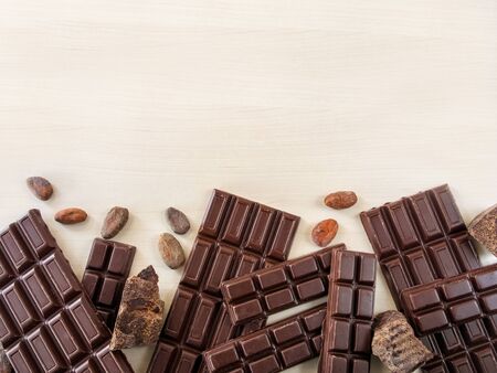 Chocolate bars, Ñhocolate beans, pieces of chocolate scattered on a light backgroundの写真素材