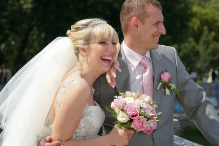 Joyful bride and groom on the nature wedding walkingの写真素材