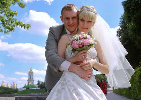Groom holding his bride on waist on their wedding walkingの写真素材