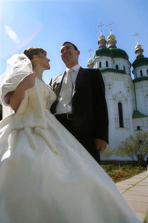 Happy bride and groom on a church backgroundの写真素材