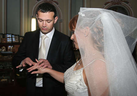 Groom arrange the wedding ring to a bride fingerの写真素材