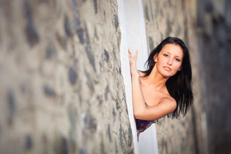 beautiful brunette young girl in style flower dress posing near black rock wallの写真素材