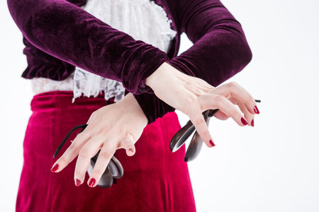 clouse up hands with castanets of a female spanish flamenco dancer in white blouse and vinous...