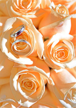 Wedding rings on bridal bouquet of yellow rosesの写真素材
