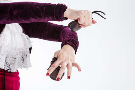 closeup hands with castanets of a female spanish flamenco dancer in white blouse and vinous flamenco skirt in studio on gray backgroundの写真素材