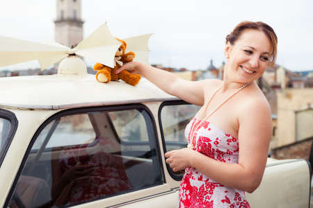 young beautiful brunette girl happy with the toy bear in her hands in old city streetの写真素材