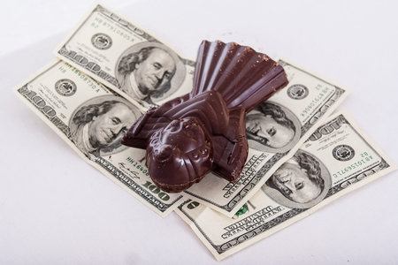 milk chocolate angel figure with dollars on gray tableの写真素材