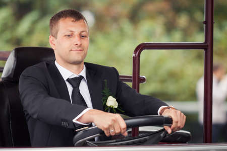 young handsome groom sit in the carの写真素材