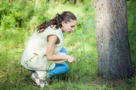 young beautiful brunette girl play in green forestの写真素材