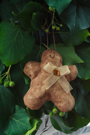 Gingerbread man handmade toy on design green New Year tree isolated on white backgroundの写真素材