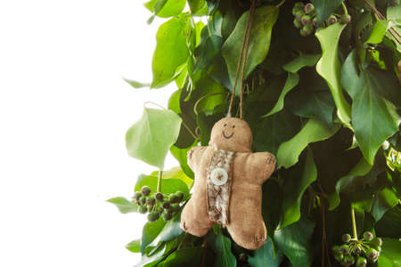 Gingerbread man handmade toy on design green New Year tree isolated on white backgroundの写真素材