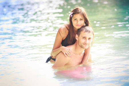 brunette girl with handsome man pose in island blue sea water in Thailandの写真素材