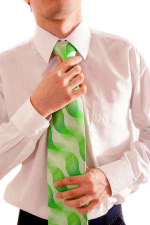 european young man in white shirt sets tie straightの写真素材